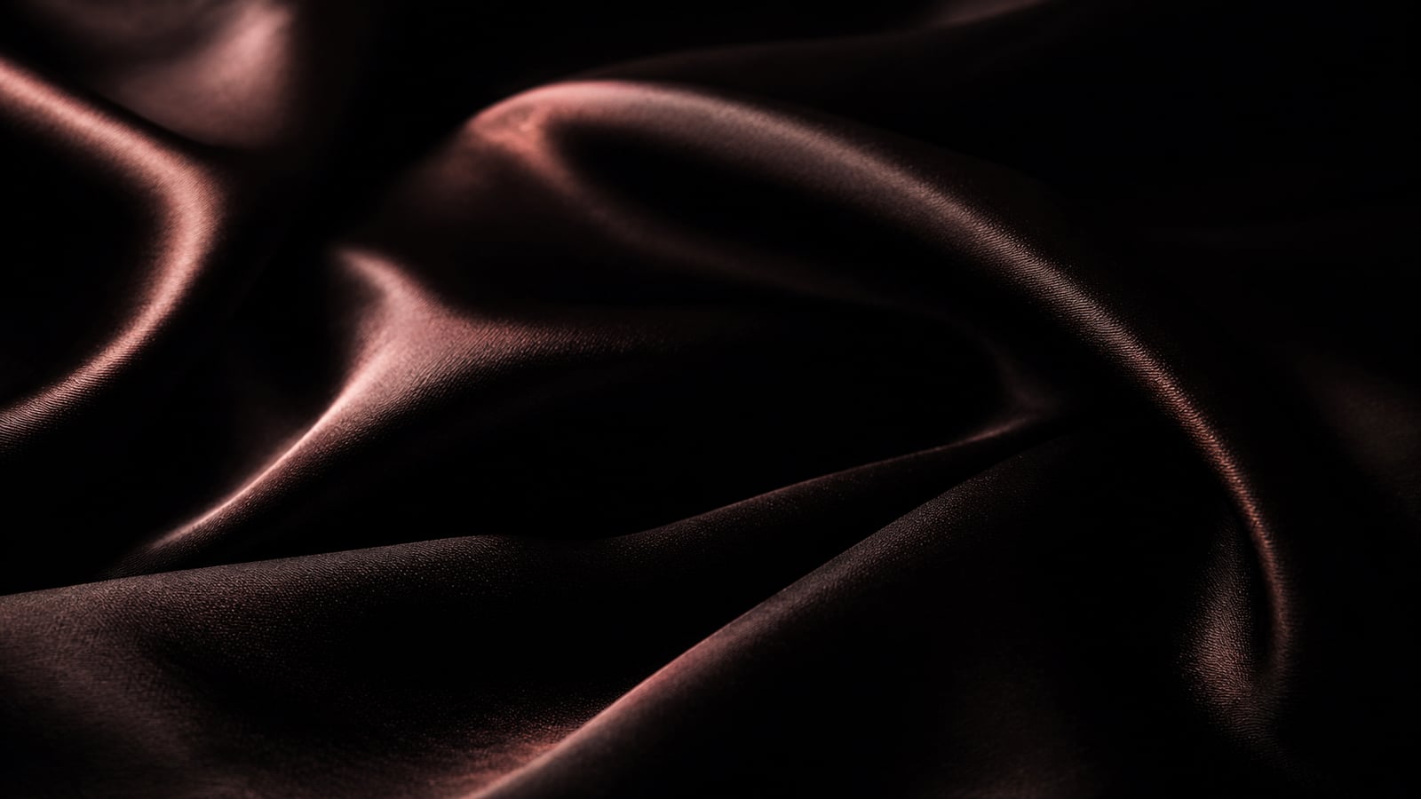 seta in chiaroscuro, pieghe morbide su fondo nero